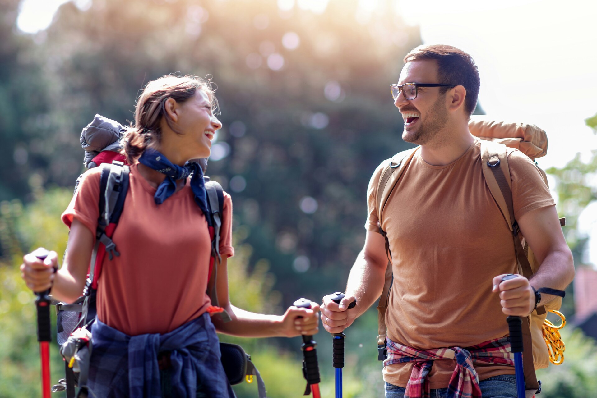 A couple hiking with backpacks along a trail, showing how shared outdoor movement strengthens connection and energy.