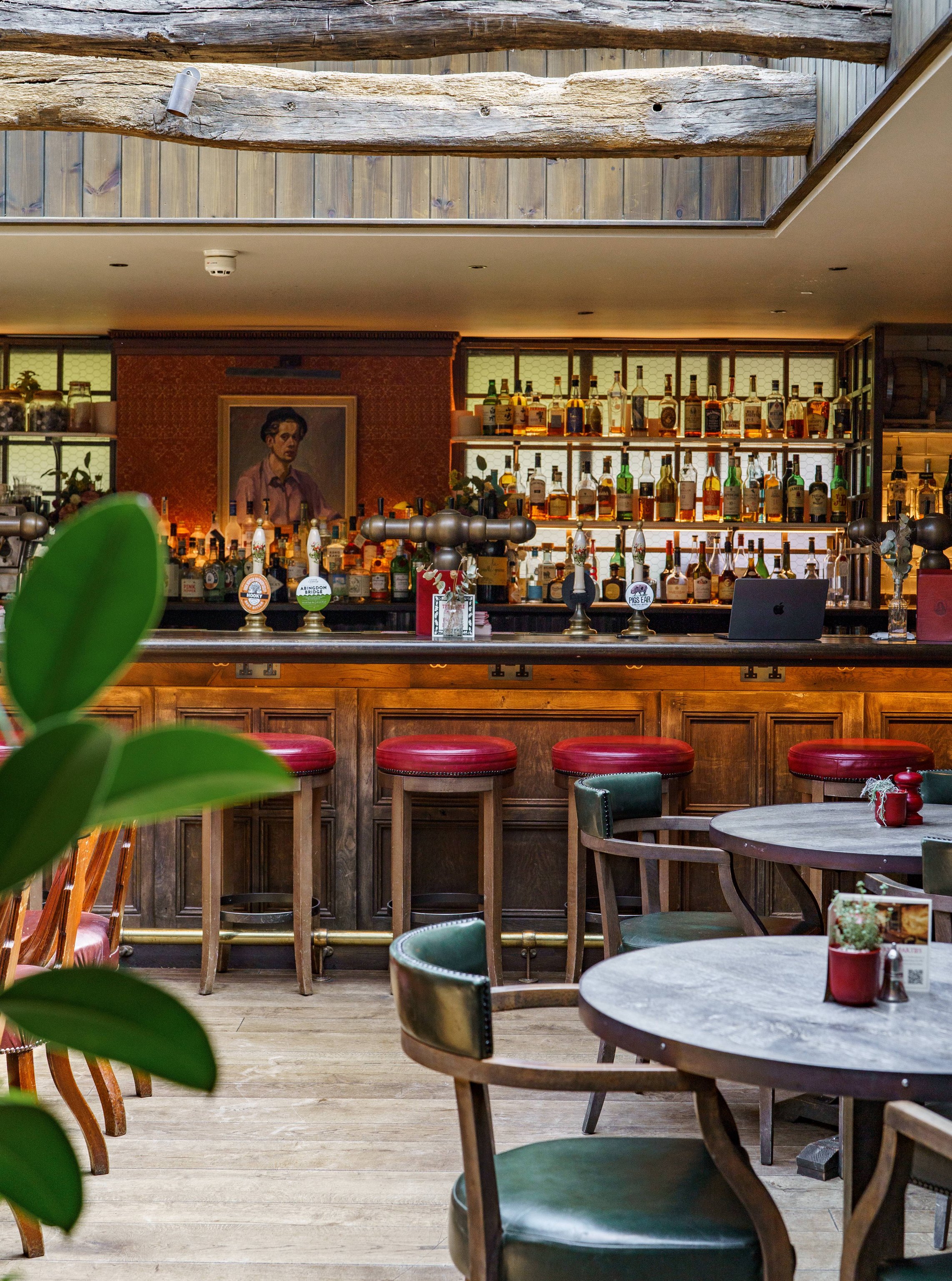 Sunlit bar and round café tables at The Double Red Duke