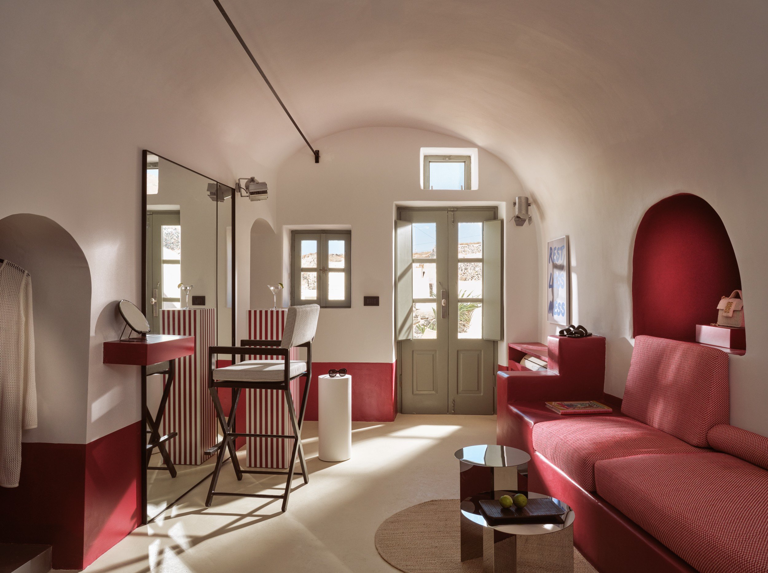 Red and cream sitting area beneath an arched ceiling at Domes Neema Maison Finikia