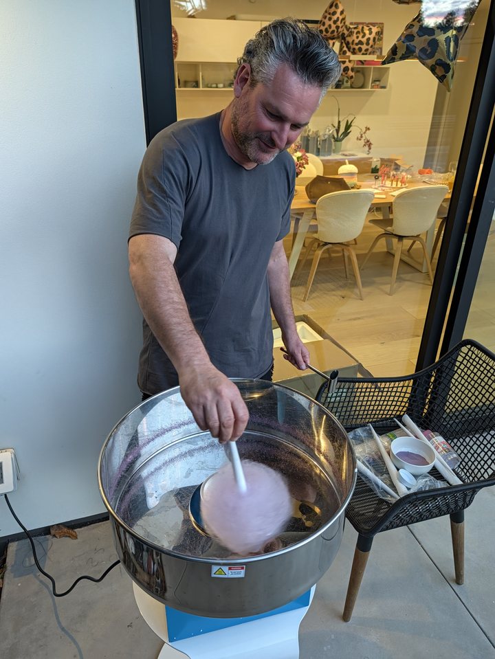 Frederik spinning pink cotton candy at the birthday party.