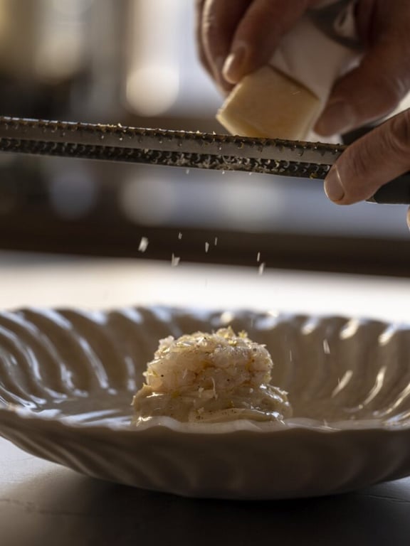 Cheese being grated over a dish at Carlton Hotel St. Moritz