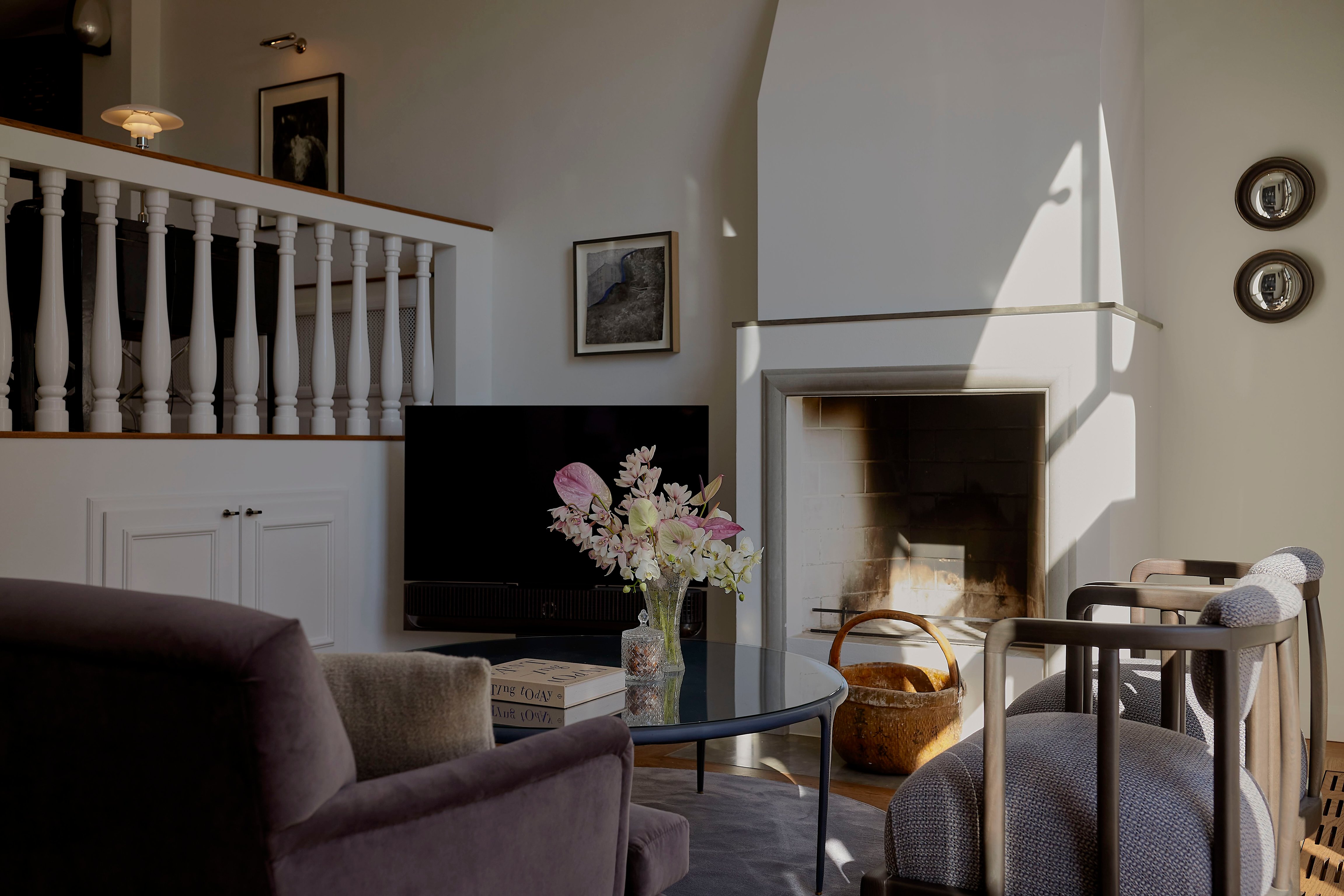 Elegant Nimb Hotel sitting room with a fireplace and curved staircase