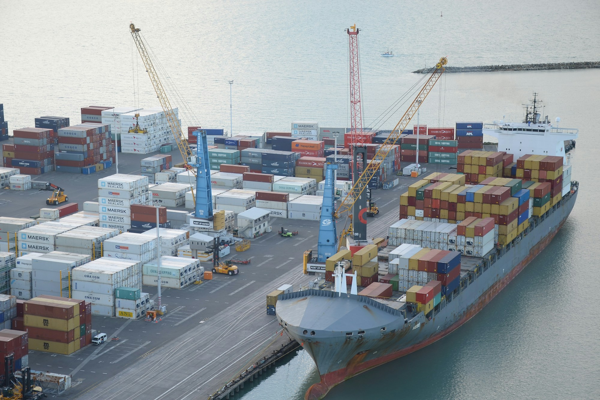 Cargo ship being loaded with shipping containers at a wharf