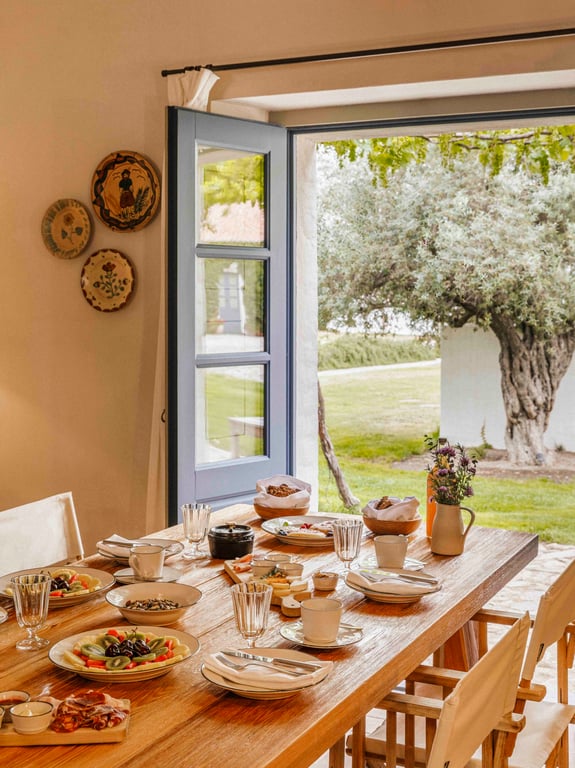 Farmhouse dining table beside an open garden door at São Lourenço do Barrocal