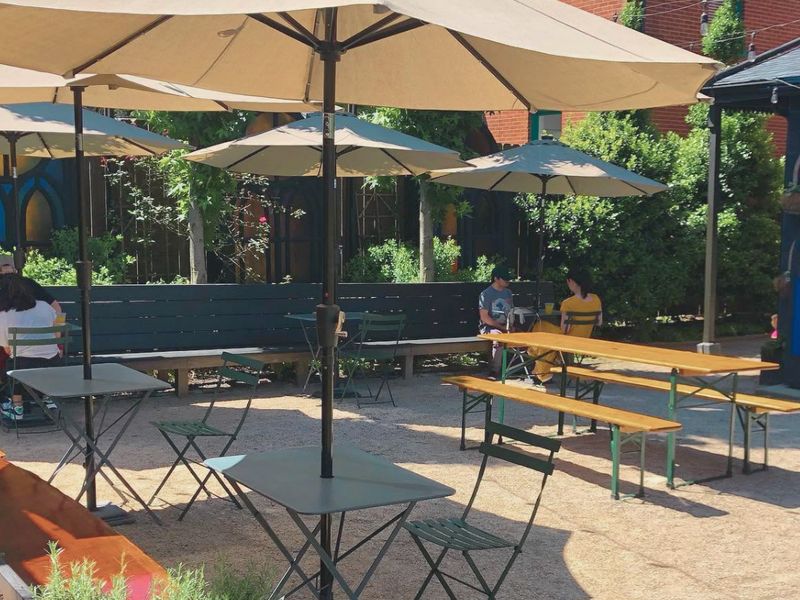Gravel beer garden with umbrellas and communal tables at Gralehaus