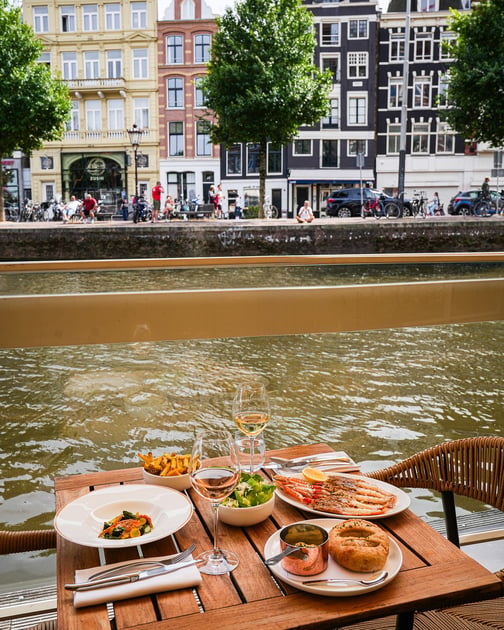 Breakfast on a canal-side terrace at Hotel De L’Europe Amsterdam