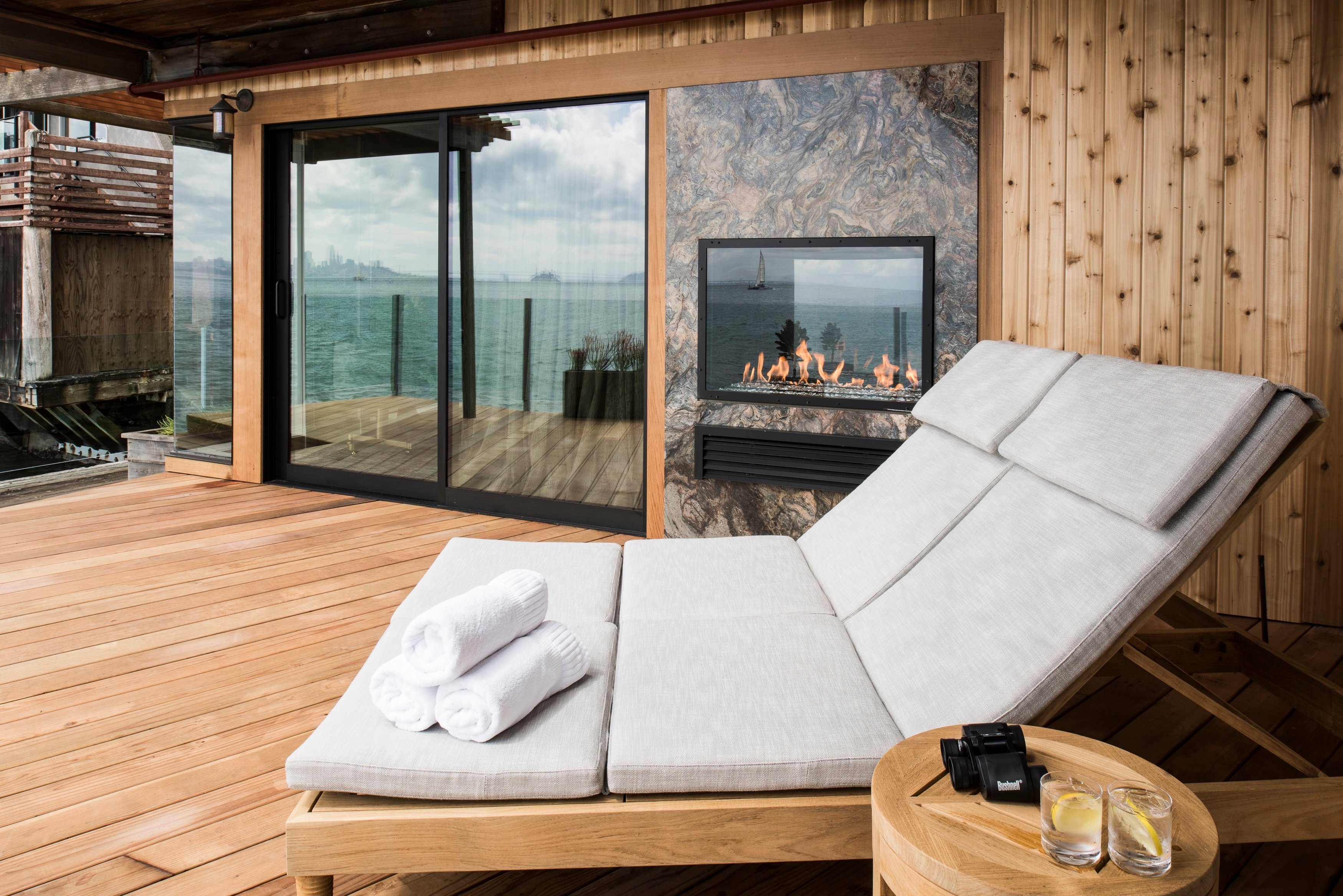 Private deck with a lounge chair and fireplace at The Inn Above Tide