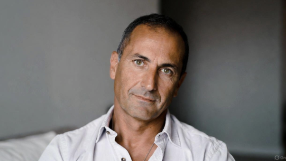 Man gently stretching neck while seated