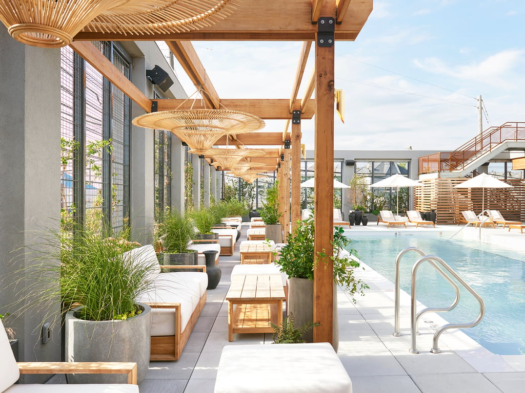 Poolside seating beneath a wooden pergola at The Rockaway Hotel + Spa
