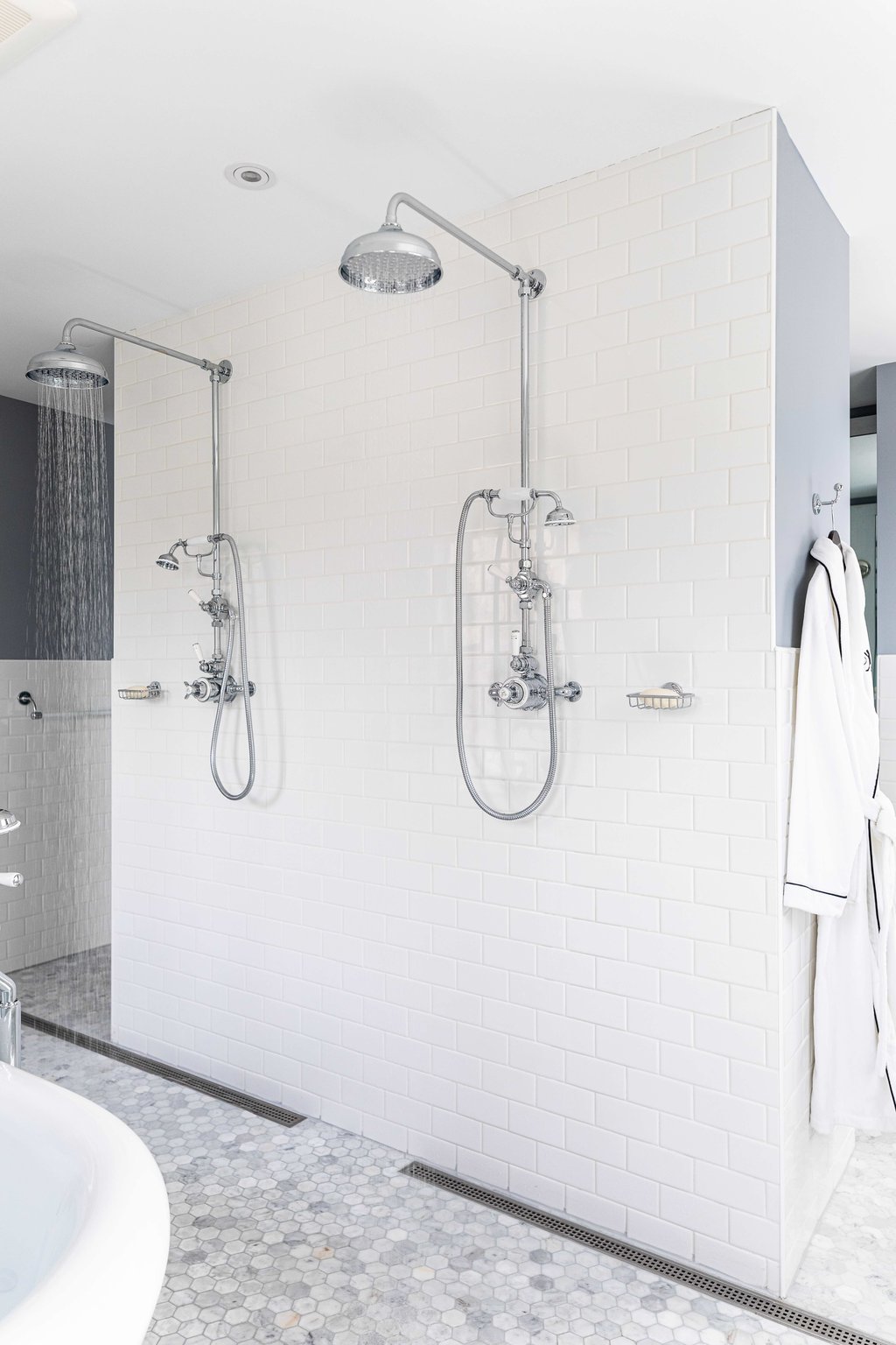 Marble walk-in shower with classic fixtures at The Weston