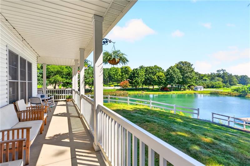 Colonial home on 2.75 acres with a covered wrap-around front porch overlooking a private pond, Center Township
