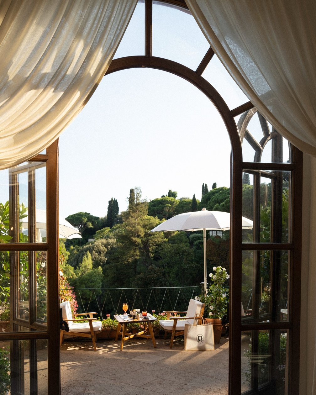 Curtained arched doorway opening onto a private garden terrace