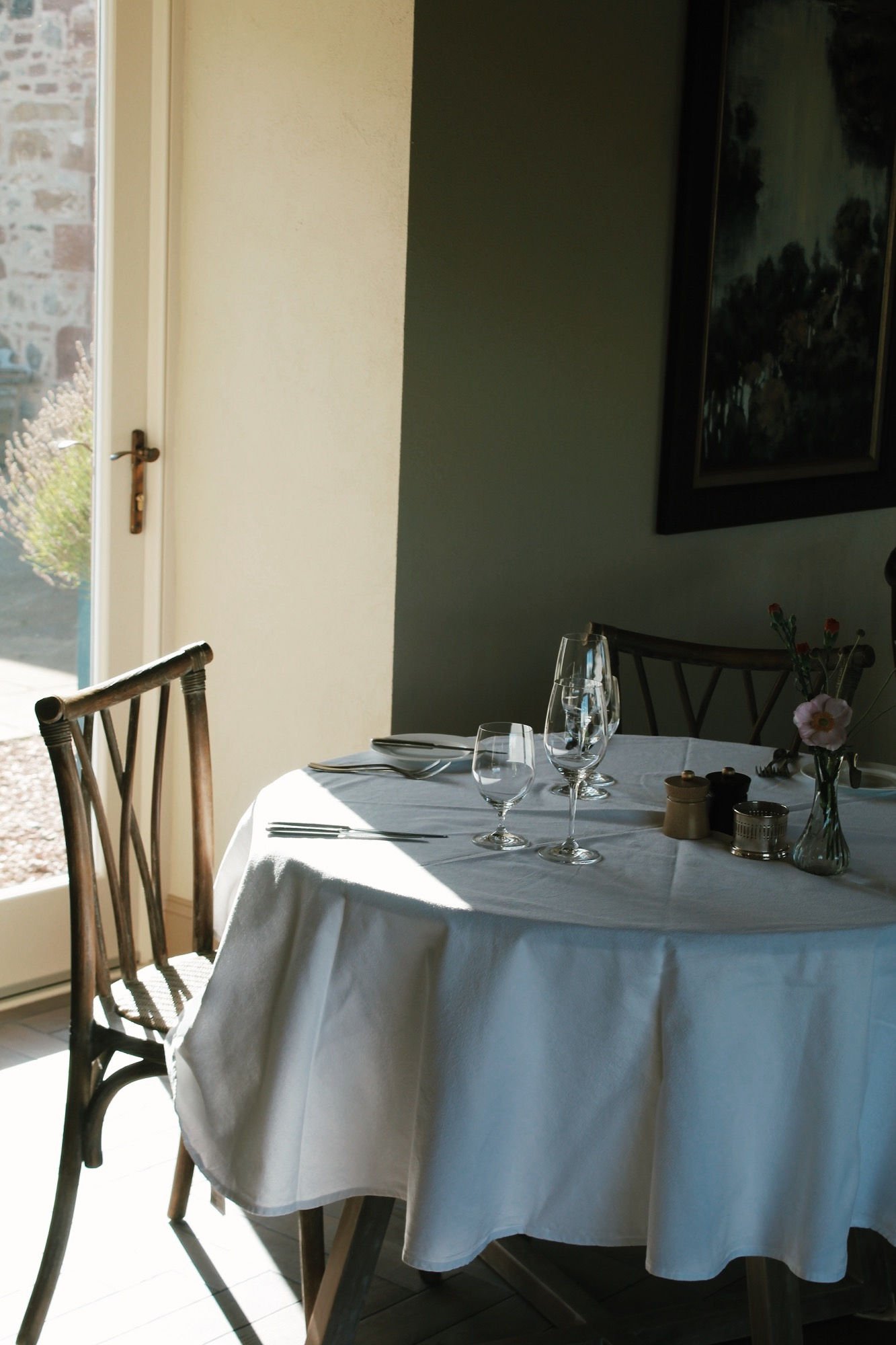 Sunlit dining table beside a window at Newhall Mains