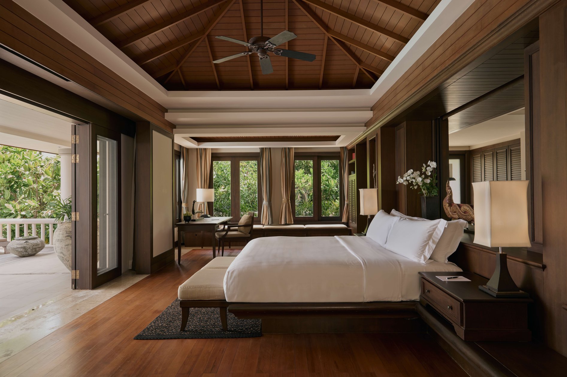 Trisara Phuket villa bedroom with timber ceiling and doors opening outdoors