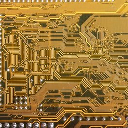 Workers on an electronics factory floor inspecting circuit boards.