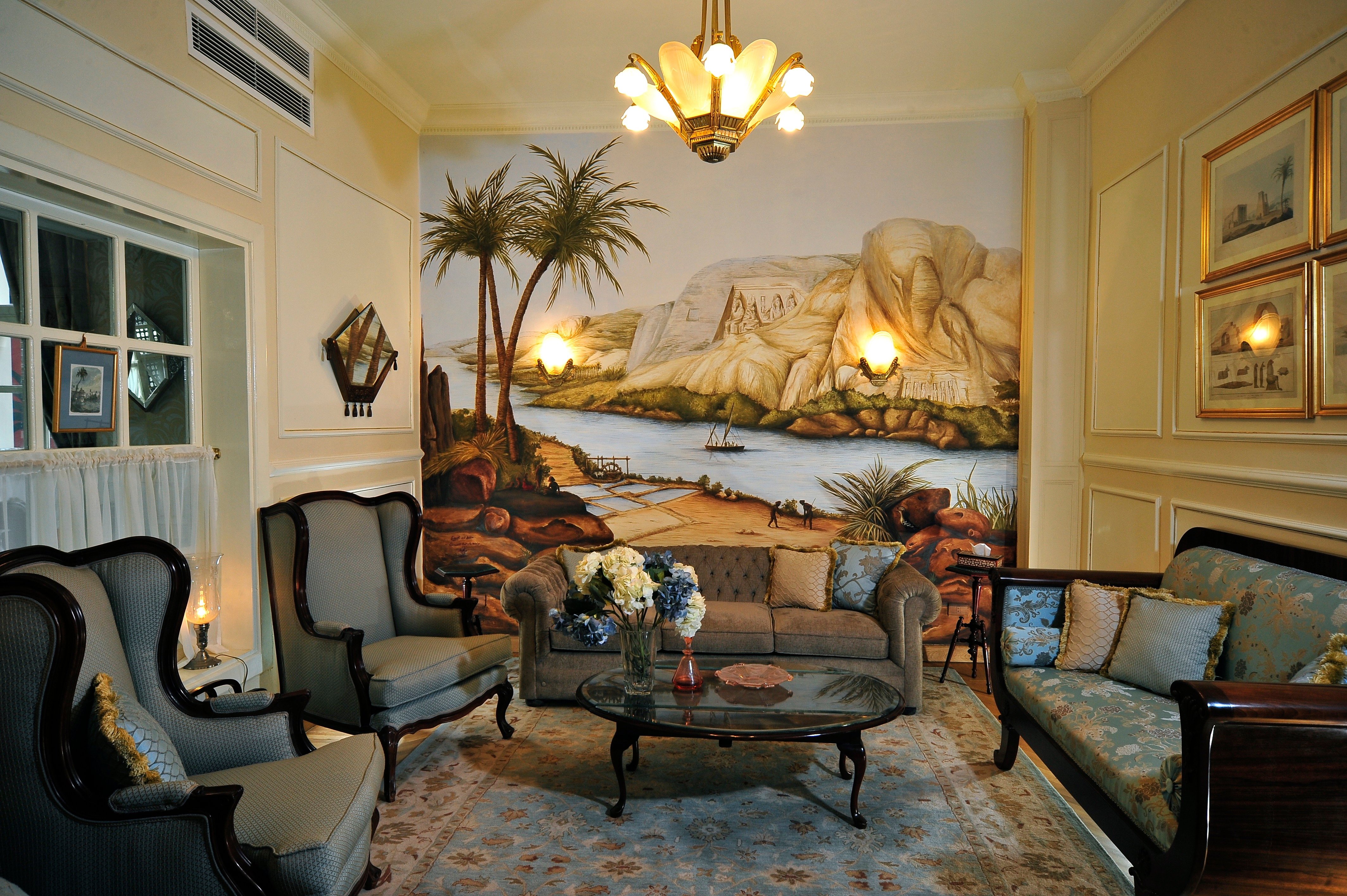Antique furnishings and a landscape mural at Villa Belle Époque