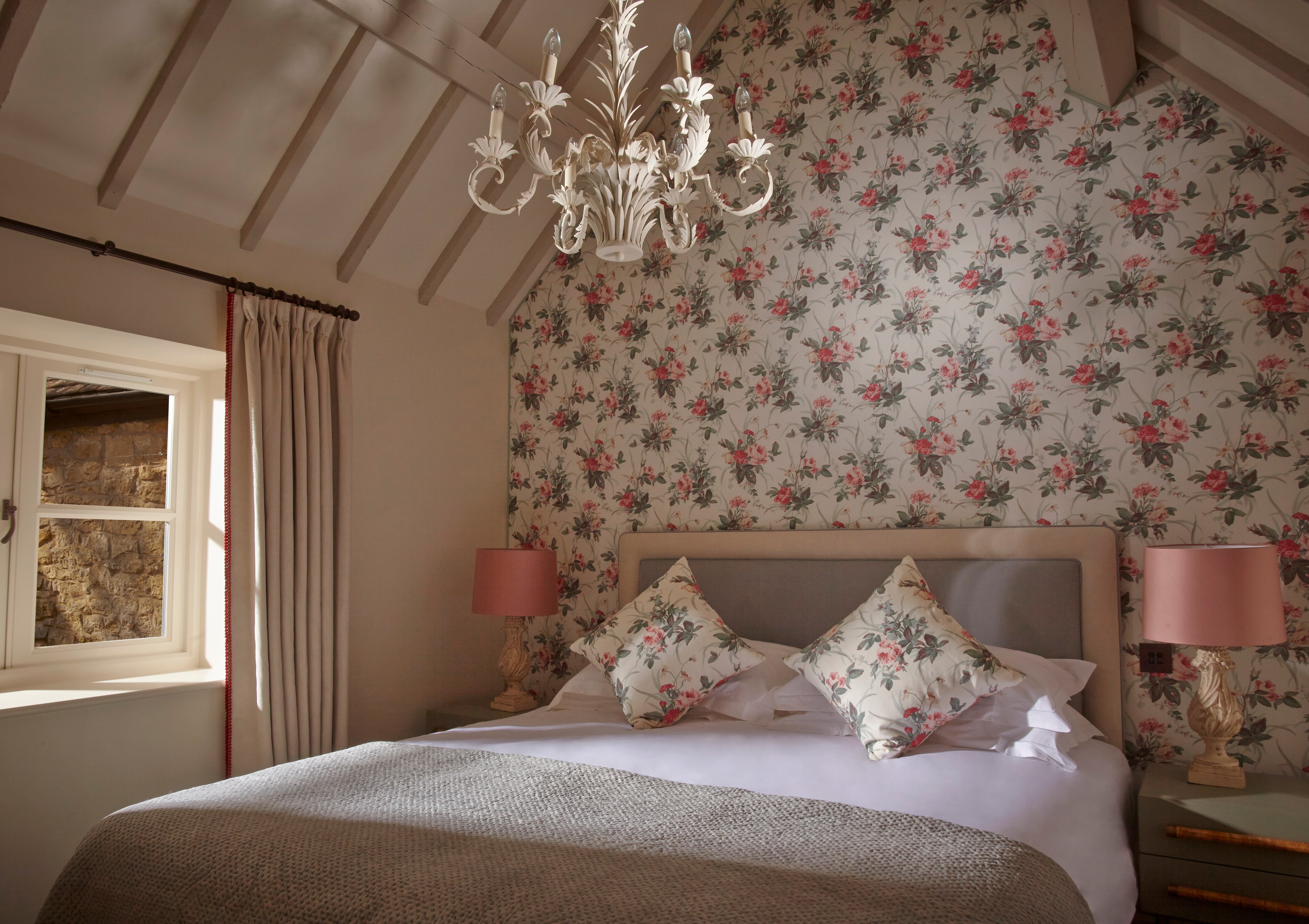 Floral wallpaper and a chandelier in a Dormy House bedroom
