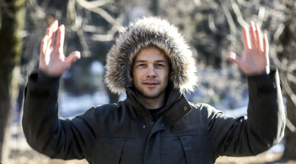 Man warming hands by swinging arms before going outside