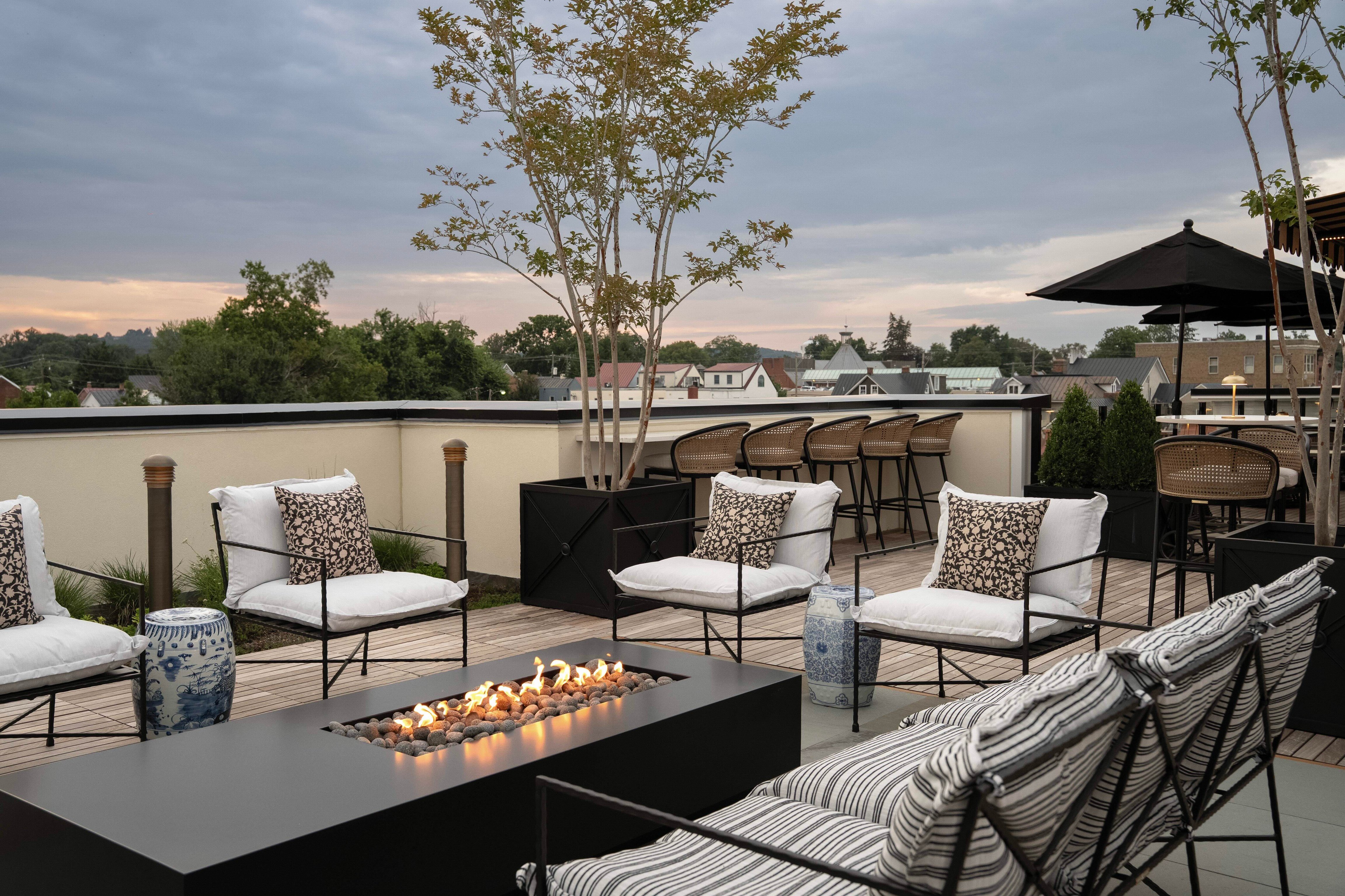 Hotel Burg rooftop terrace with cushioned seating and a long fire table