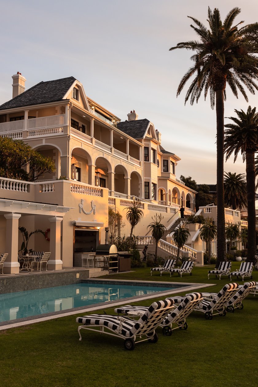 Ellerman House exterior and swimming pool at dusk beneath palm trees