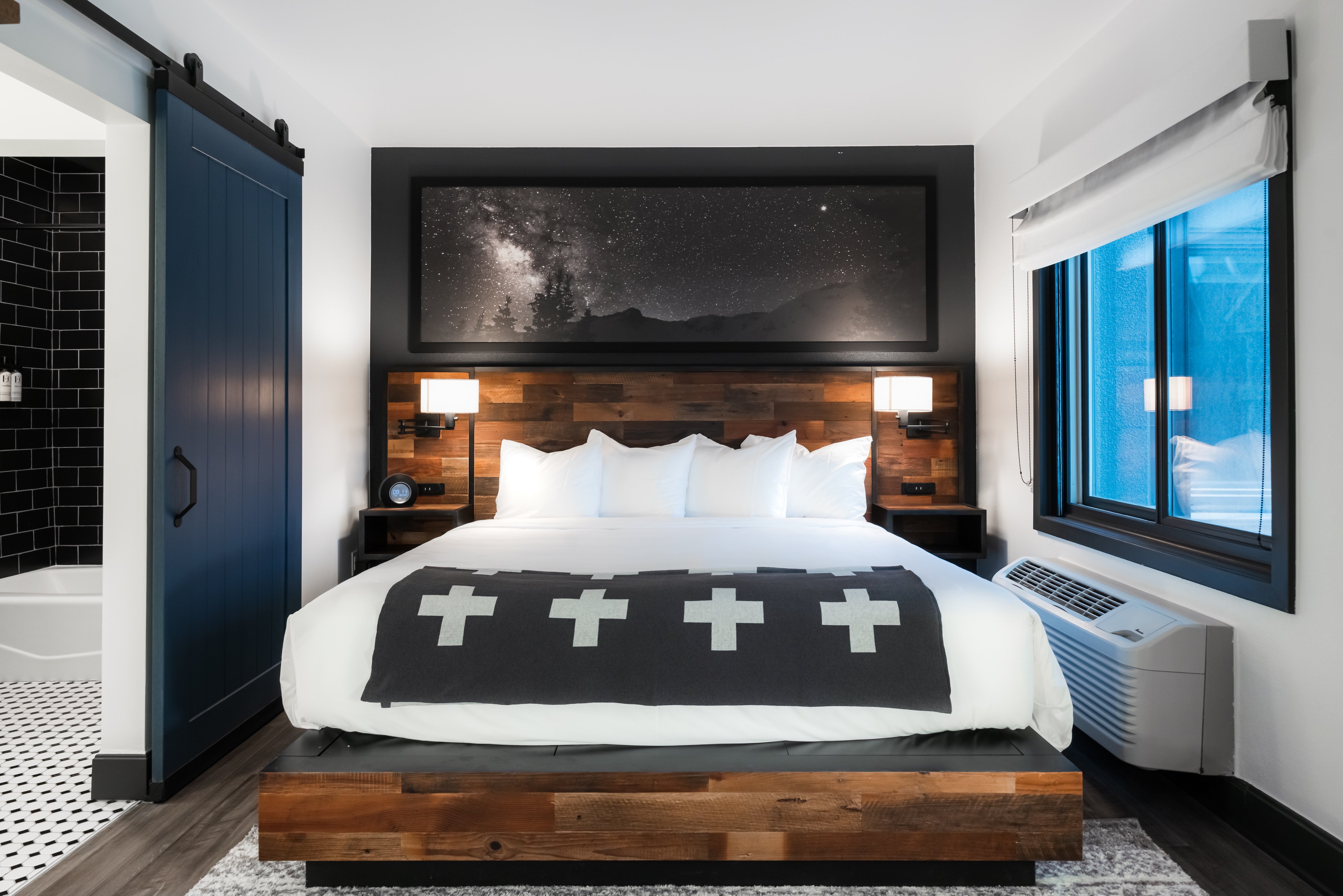 Guest room with a mountain photograph and patterned blanket at Gravity Haus Breckenridge