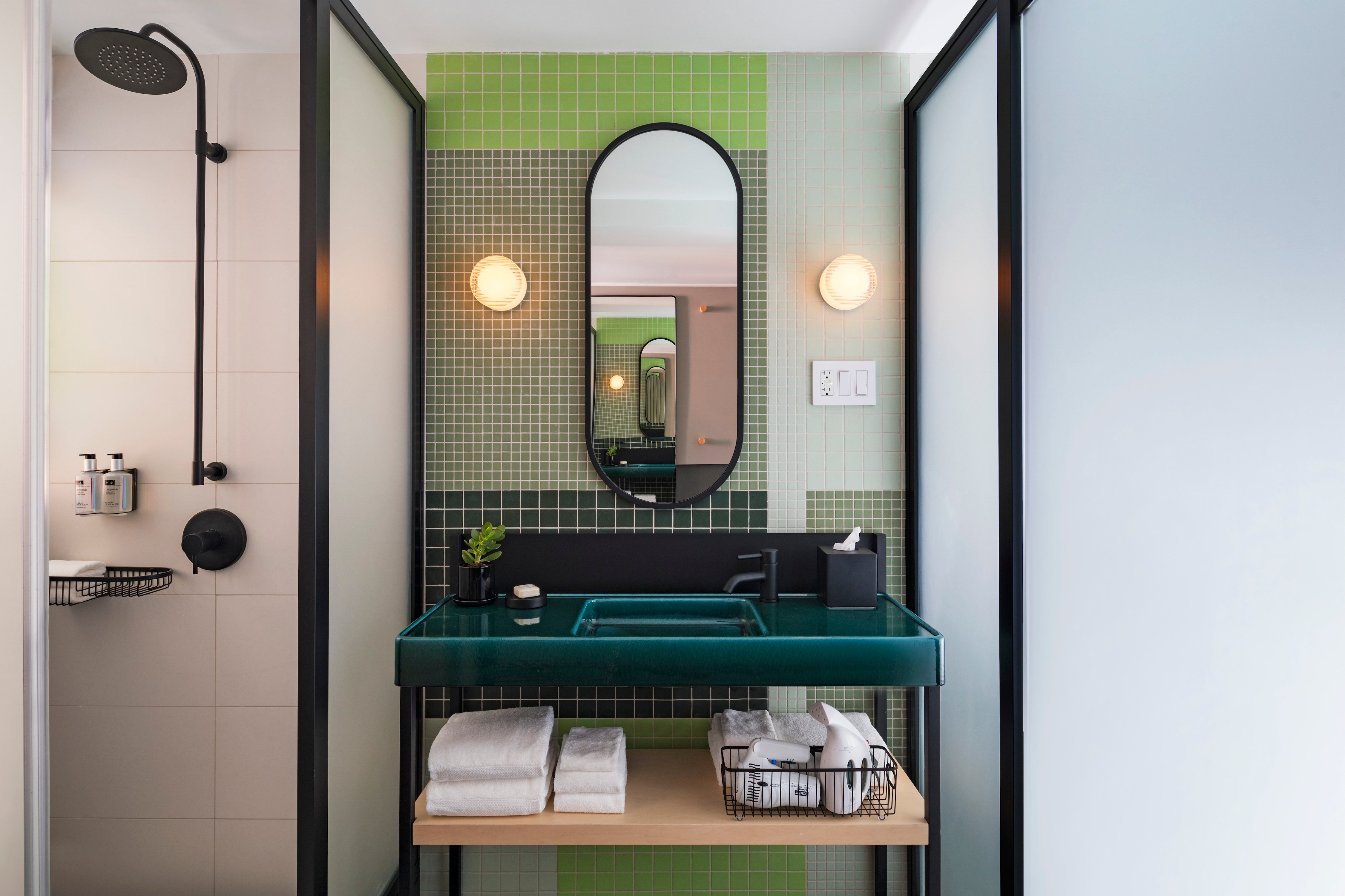 Guest bathroom with green tile, a pedestal sink, and a glass shower