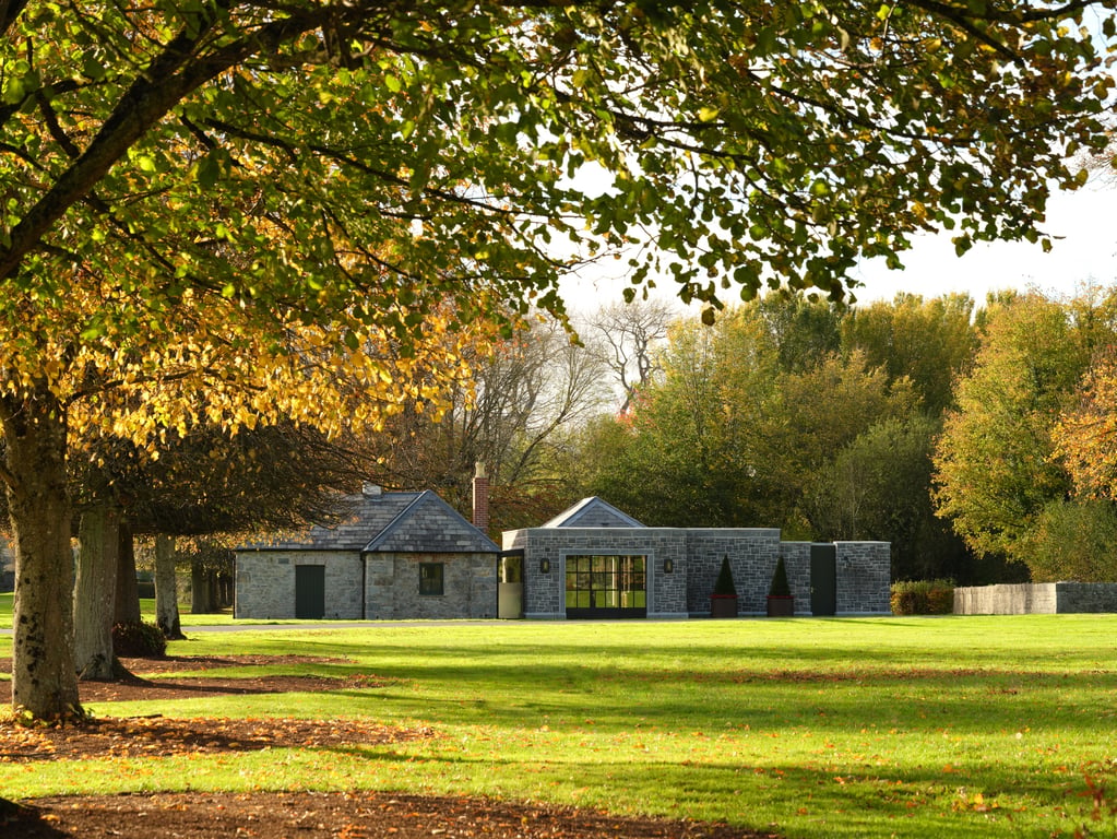 Tree-lined grounds and recreation buildings at Adare Manor