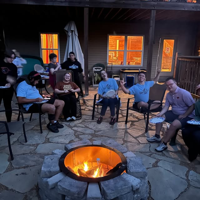 Camp Circle Star campers and volunteers sitting around a campfire
