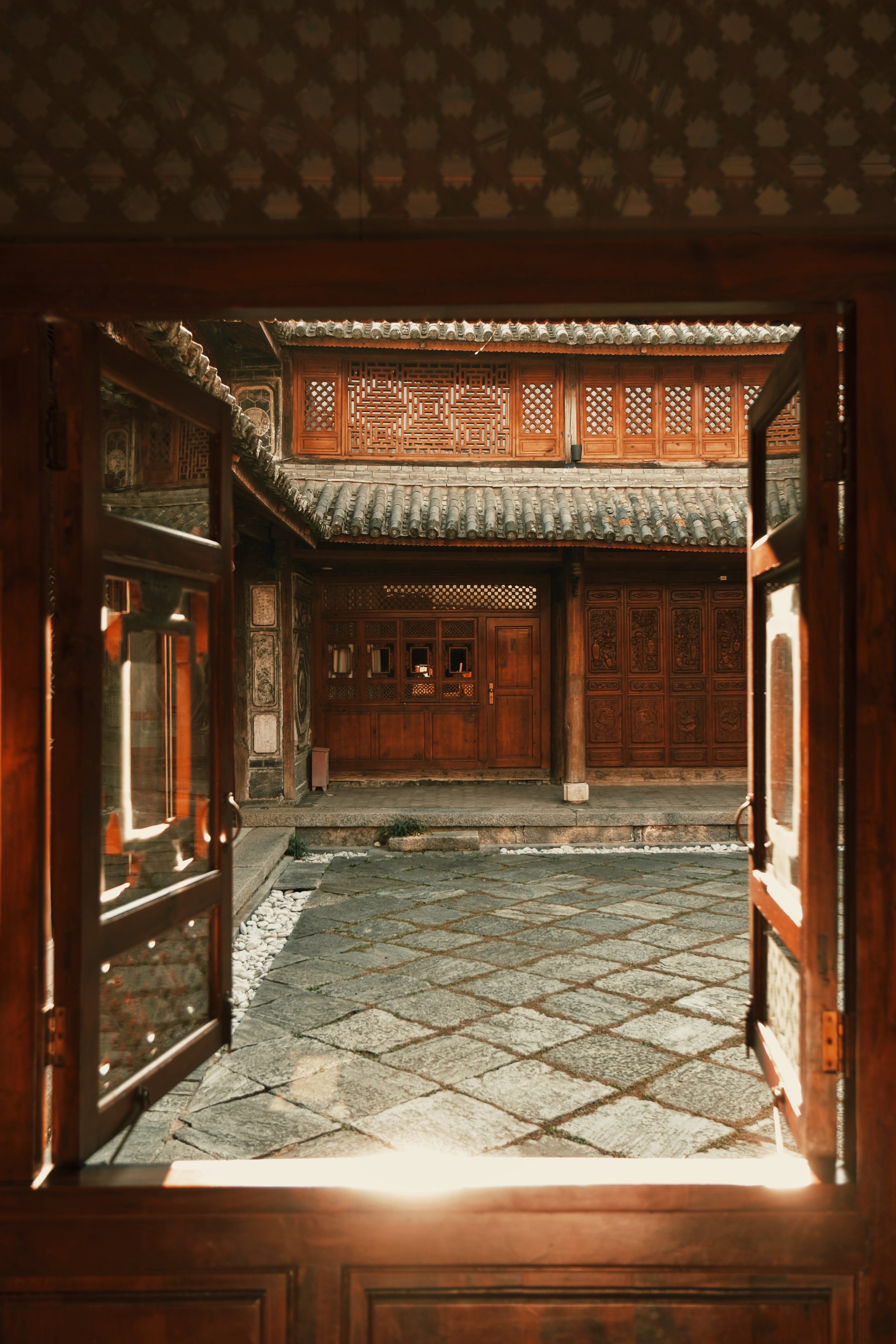 Stone courtyard and carved wooden doorways at Sky Valley Heritage Boutique Hotel