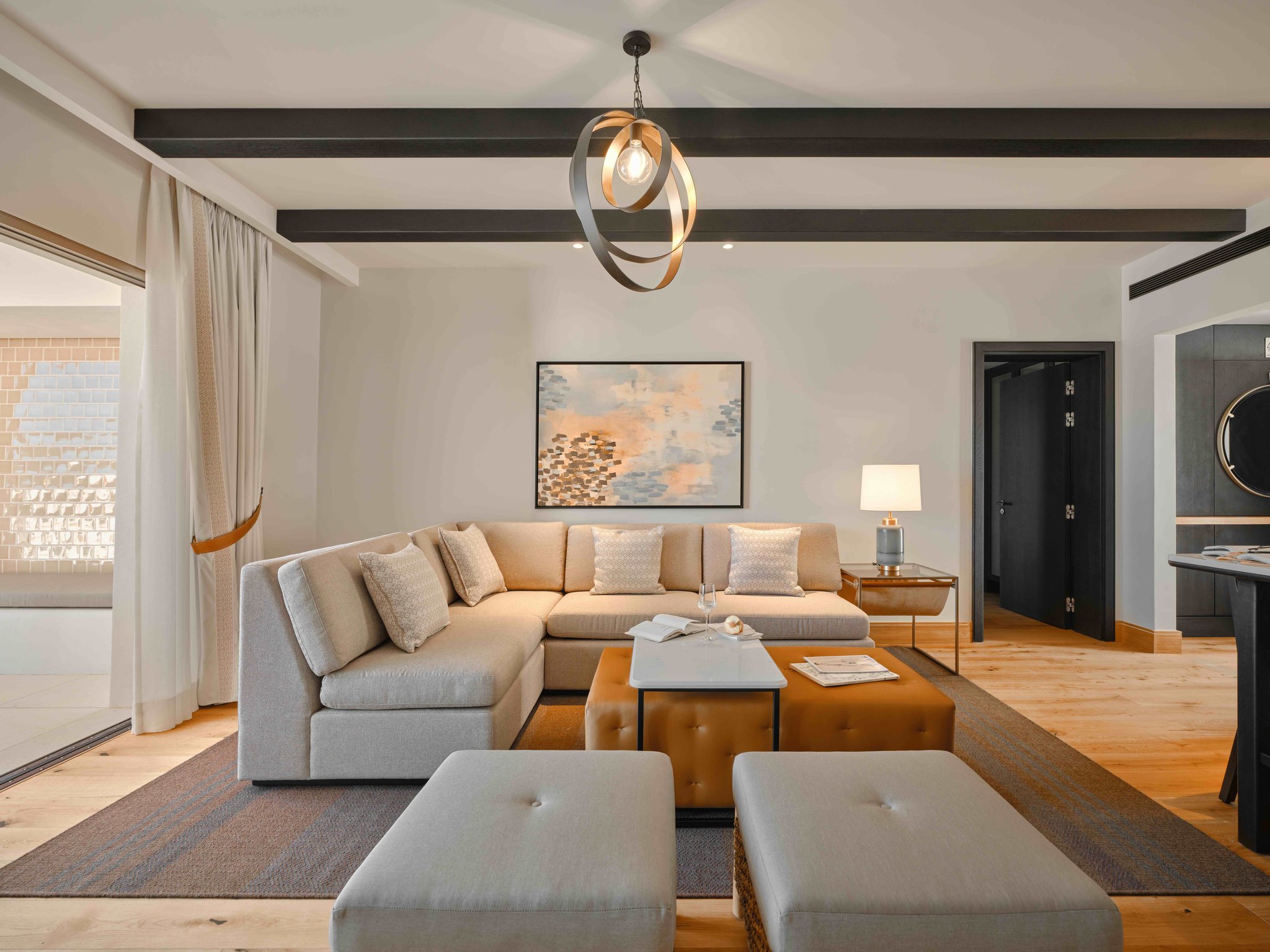 Suite living area with pale sofas and dark ceiling beams at Viceroy at Ombria Algarve