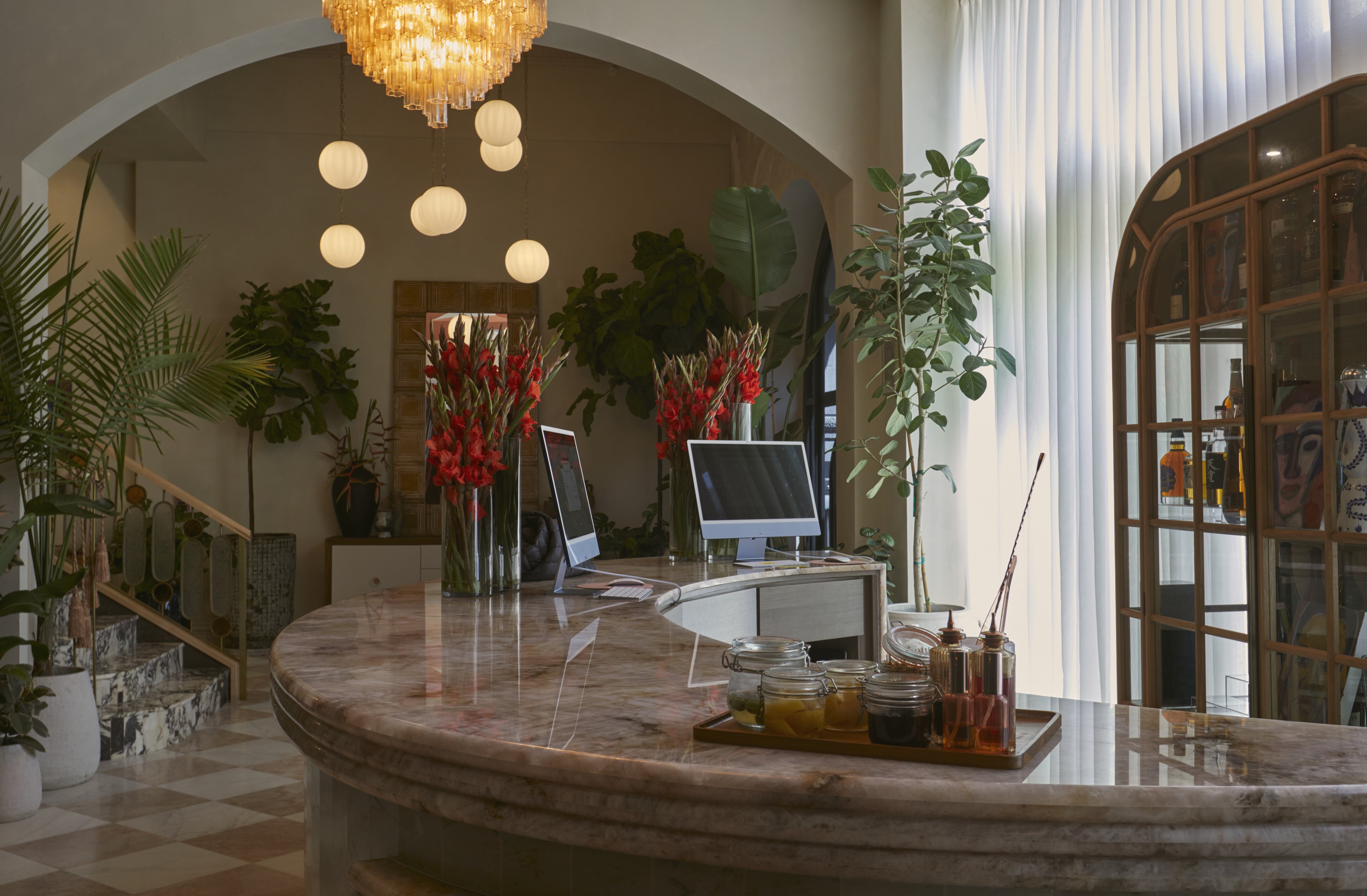 Curved marble reception desk and leafy lobby at Granger Hotel
