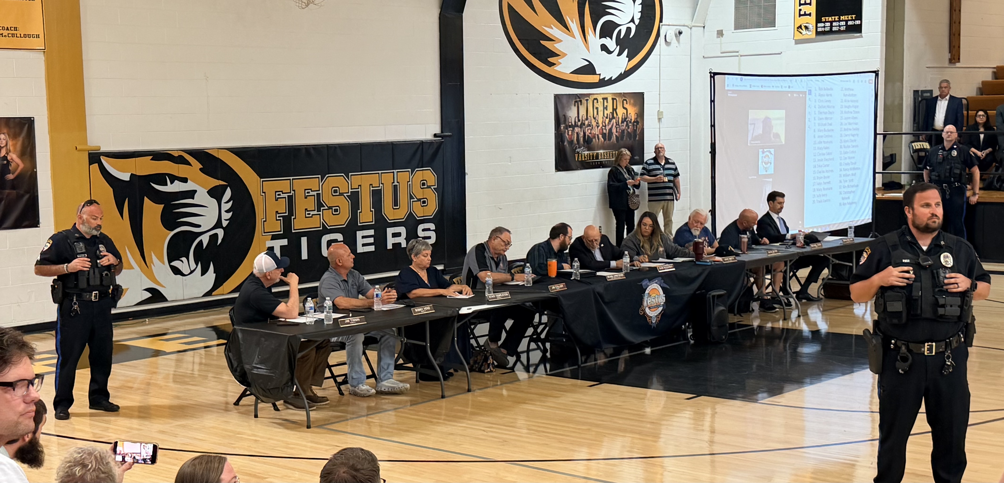 Crowd at Festus High School holding signs opposing the data center