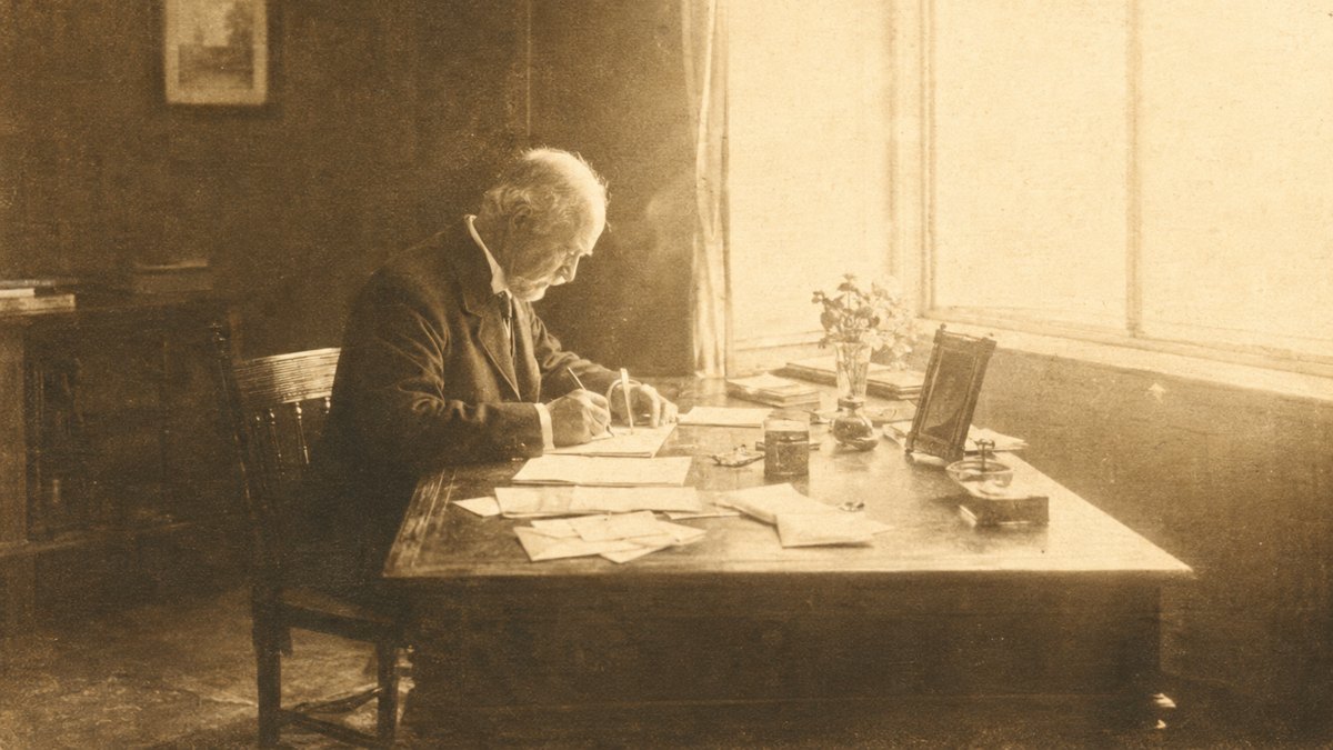 A hand writing a letter with a fountain pen