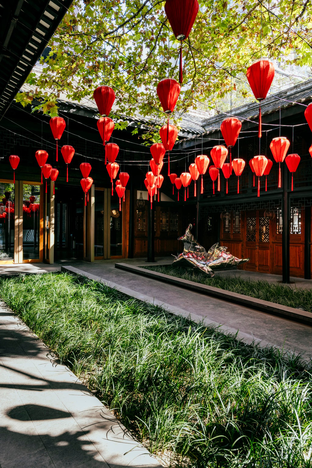 Shaded Chengdu courtyard lined with red lanterns and bamboo