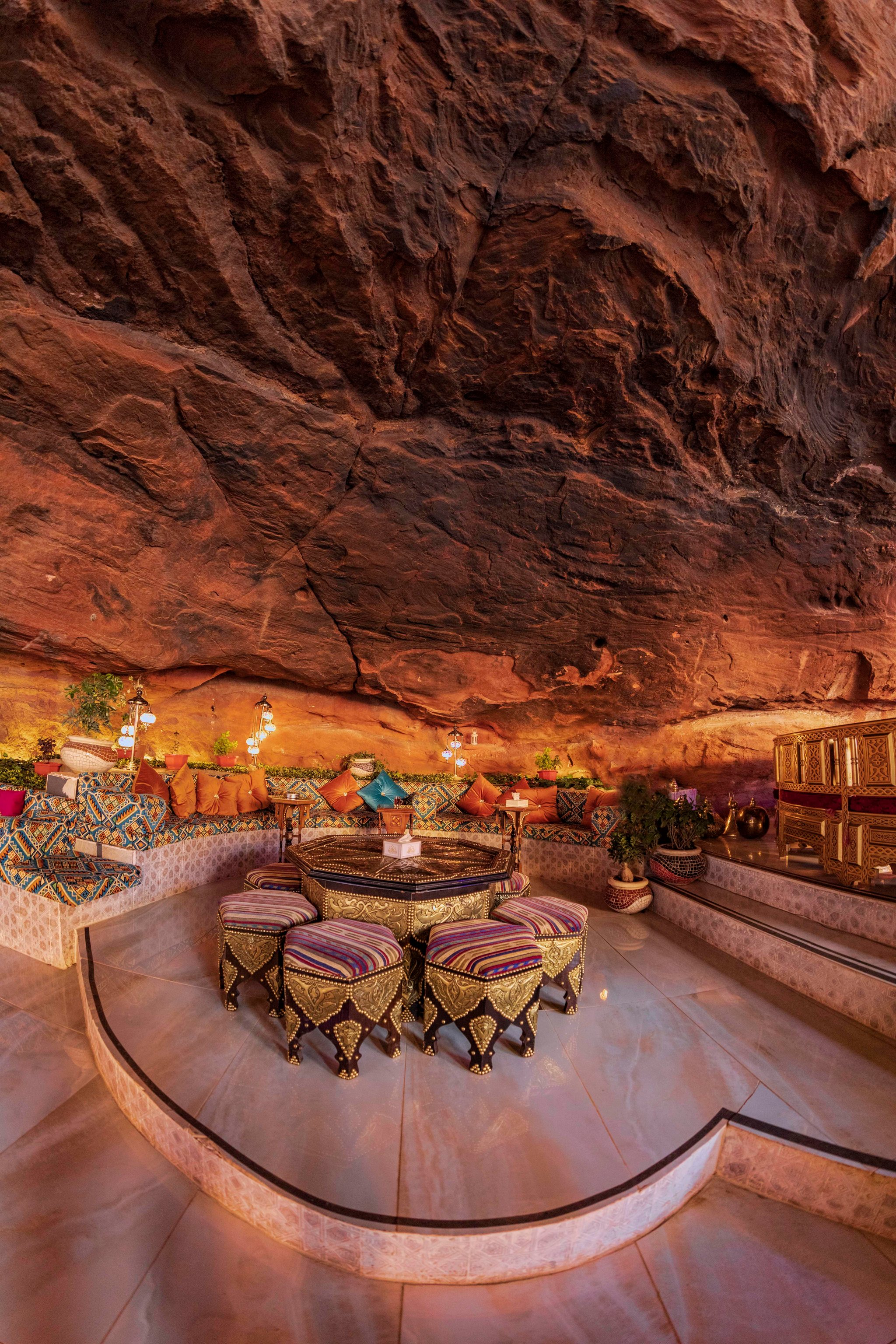Outdoor lounge beneath a rock face at Memories Aicha Luxury Camp