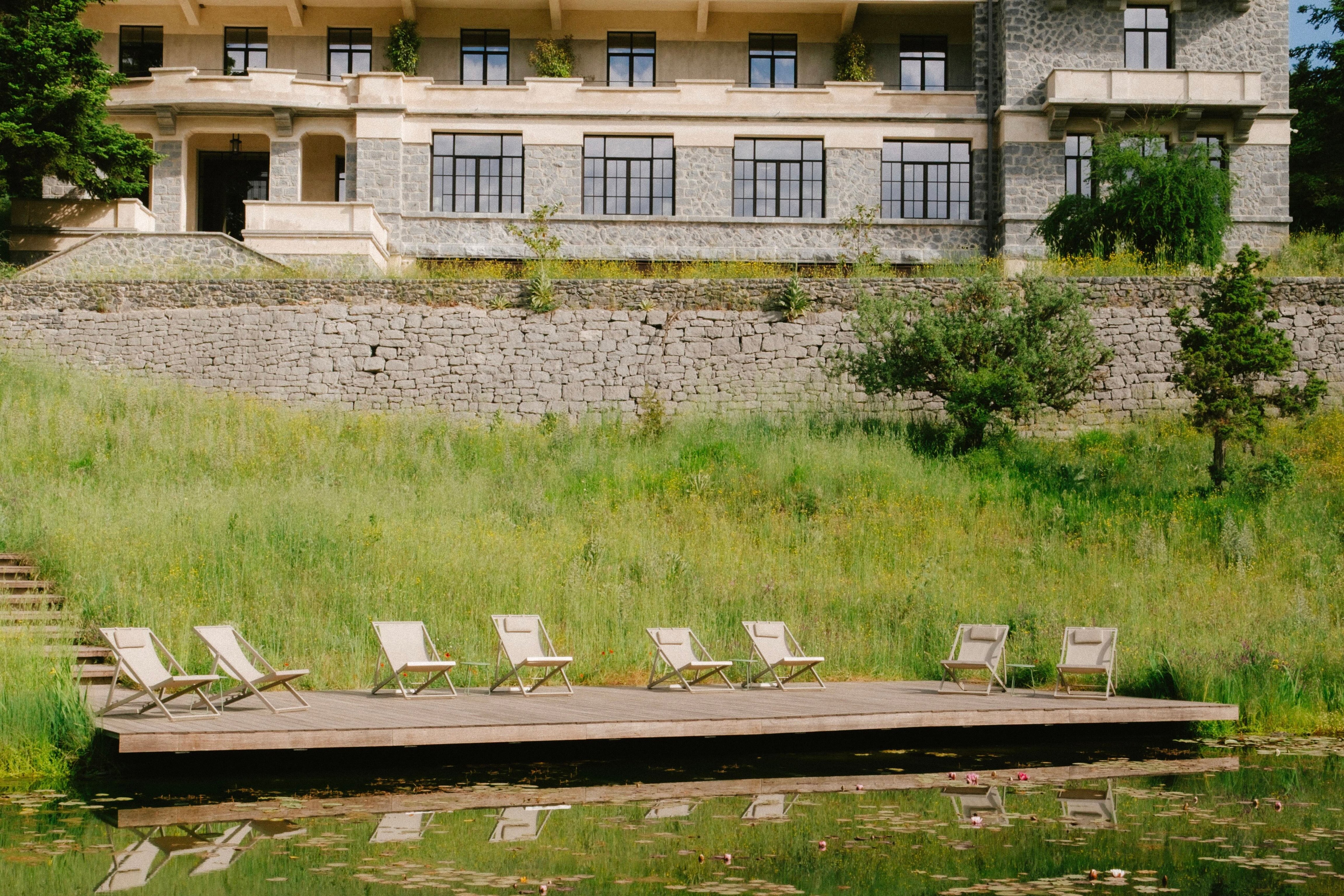 Manna hotel above a meadow with wooden loungers near a small pond