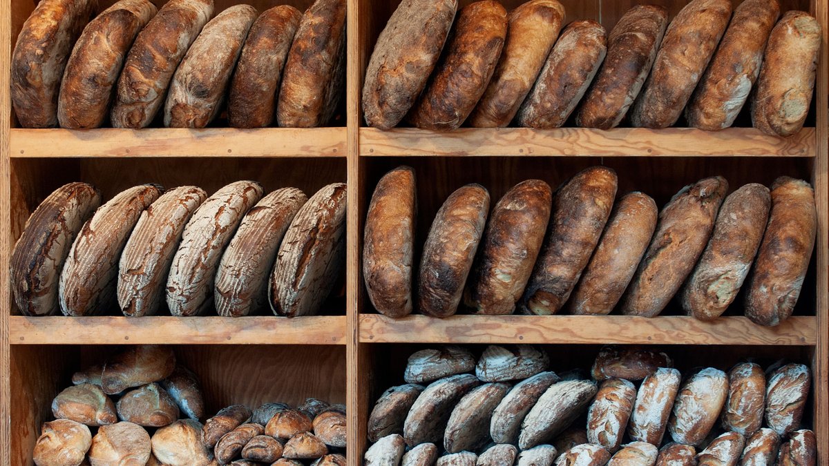 A rustic European loaf of bread on a wooden board