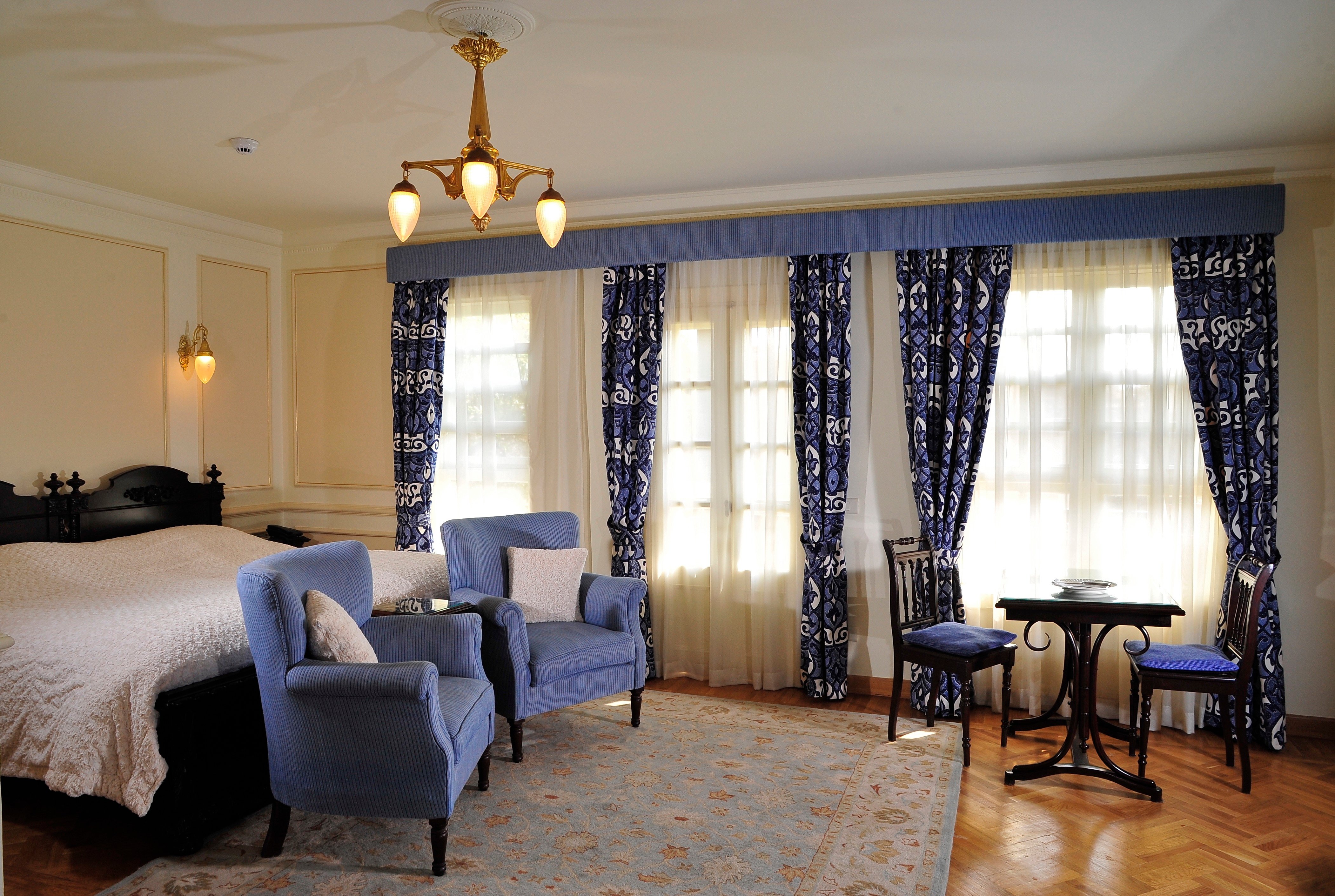 Light-filled suite with blue armchairs at Villa Belle Époque