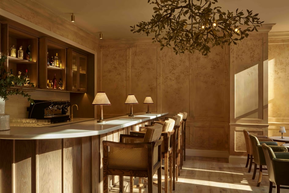 Warmly lit bar with upholstered stools