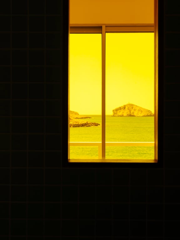 Golden Mediterranean sunset framed by a Tuba Club window