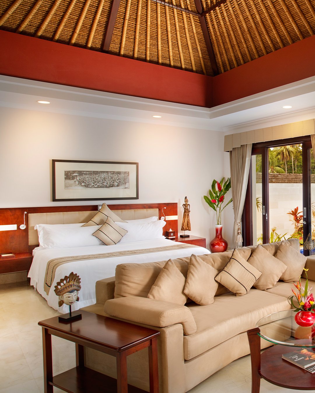 Viceroy Bali villa bedroom and sitting area beneath a high thatched ceiling