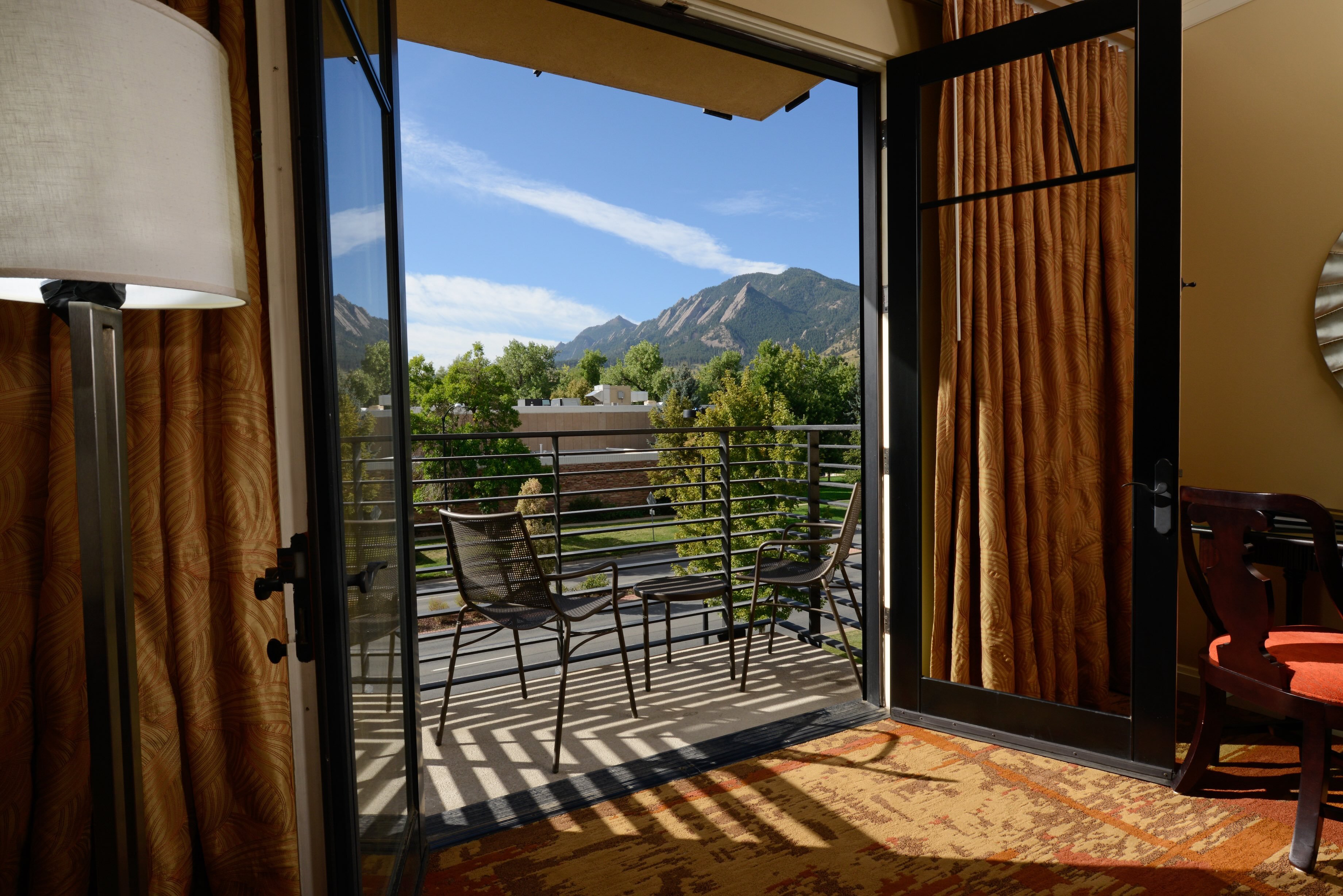 Open doors leading to a furnished balcony with mountain views