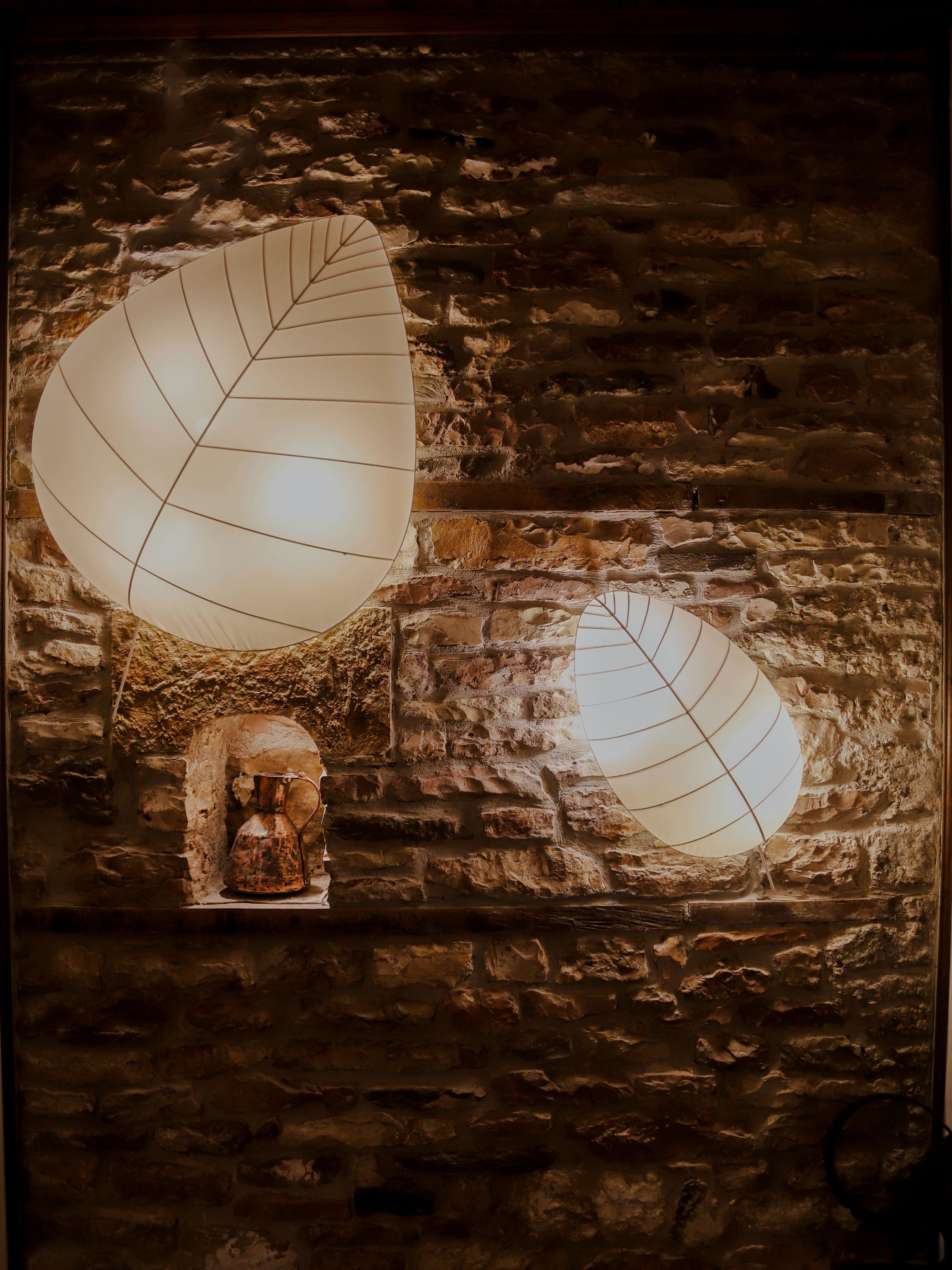 Sculptural lamps against stone walls at N’Sokak