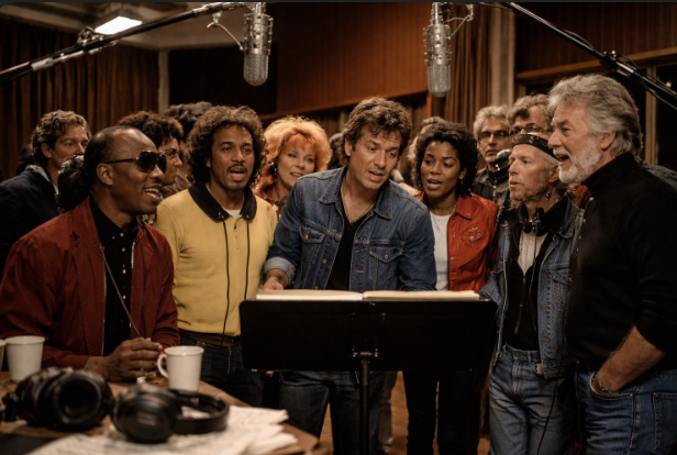 A late-night recording studio scene with microphones, headphones, and a group around a music stand