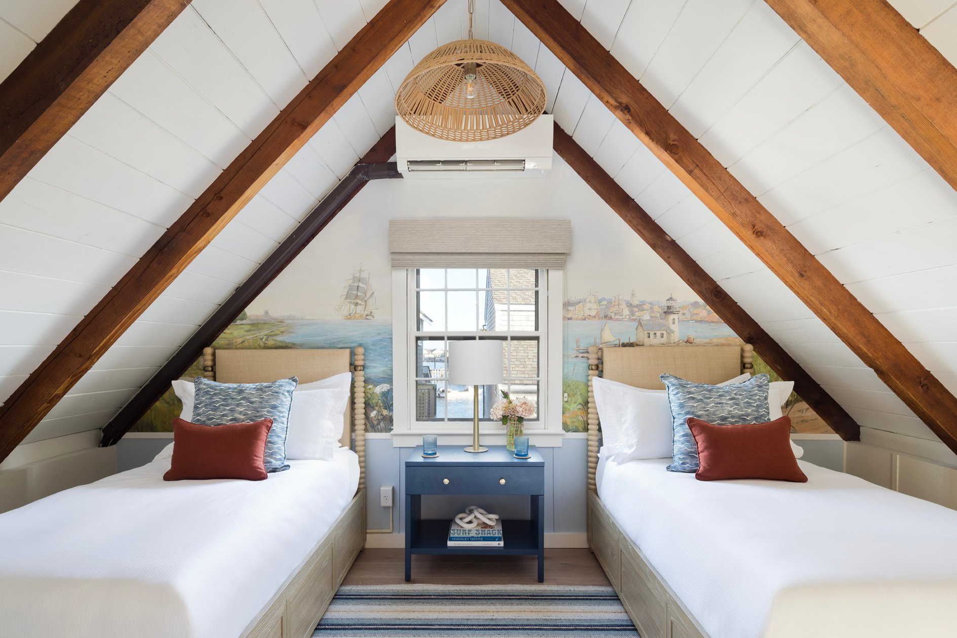 Loft bedroom with twin beds beneath exposed wood rafters