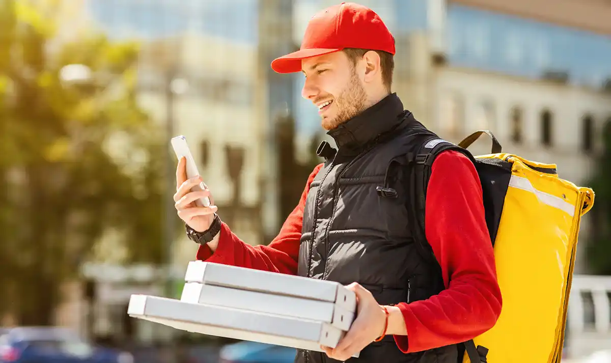 Food delivery driver checking an order on a phone