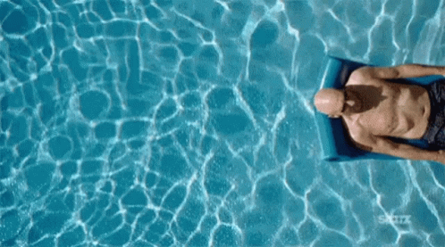 A man floating on a raft in a pool, taking it easy