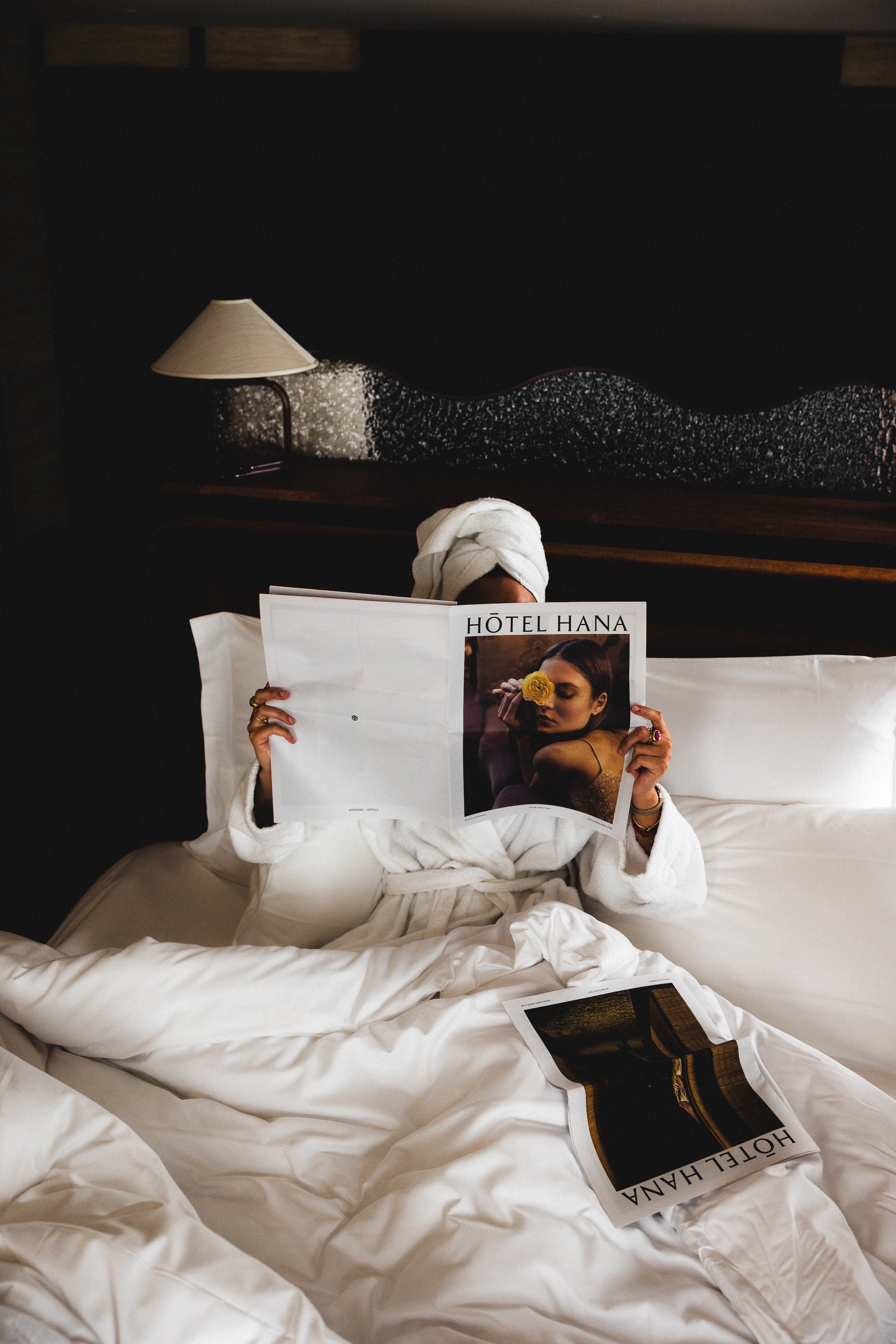 Guest relaxing with a magazine in a Hotel Hana bed