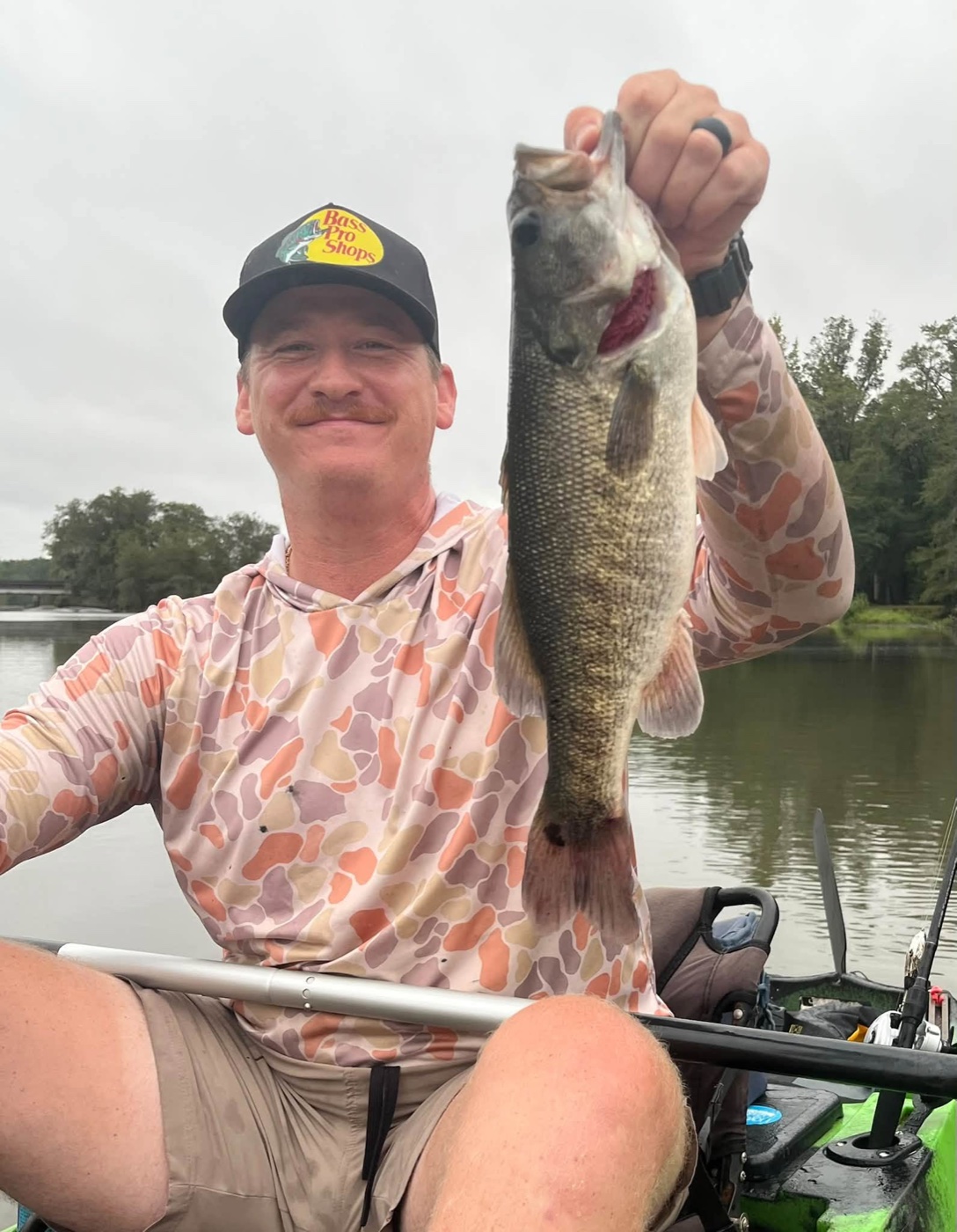 Christian Lee Brooks holding a largemouth bass from his kayak