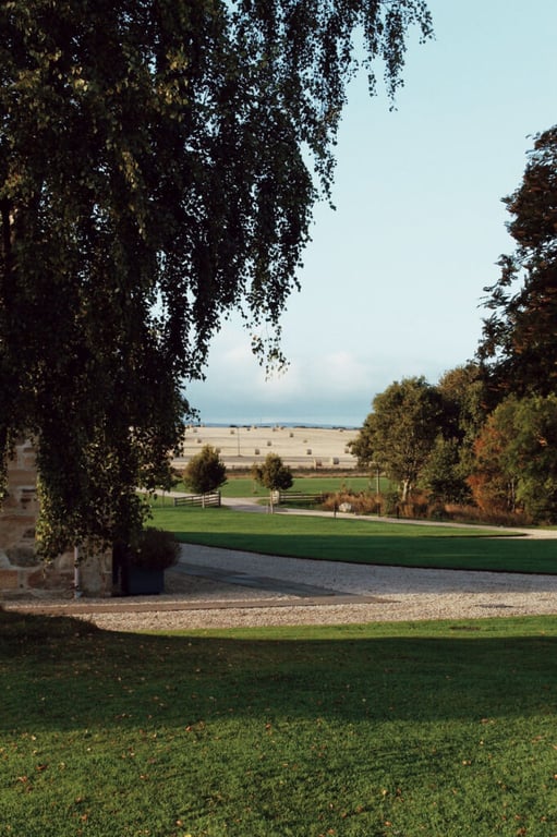 Tree-lined grounds and open fields at Newhall Mains in Scotland
